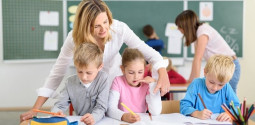 Female Teacher Helping her Young Students in classroom
