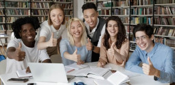 Group of six multiracial students gather in university library smiling look 