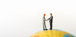 Two Businessmans mini figures standing / dealing business on Global World map