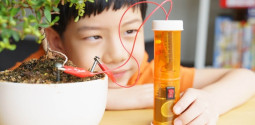 An Asian little boy proudly look at his DIY soil moisture meter